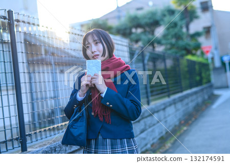 High school girls going to and from school for club activities on a cold day High school students wearing winter clothes and carrying hand warmers going to school Blazers 132174591