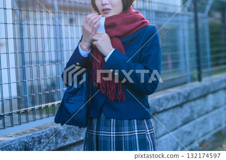 High school girls going to and from school for club activities on a cold day. High school students wearing winter clothes and carrying hand warmers. Going to and from school. Trimming. 132174597