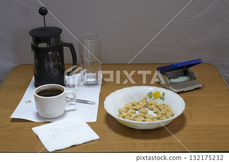 Still life with a coffee press and a hole punch. Still life with a coffee press and a hole punch. 132175232