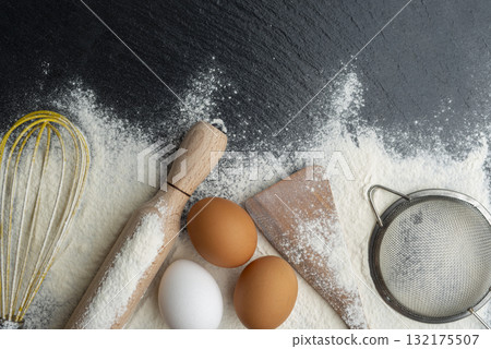 Baking utensils laying on flour background flat lay view with copyspace Baking utensils laying on flour background flat lay view with copyspace 132175507
