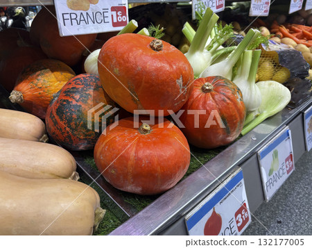 Fresh squash vegetable displayed at local market in France, arranged alongside seasonal vegetables, colorful autumn harvest scene with natural texture, organic product 132177005