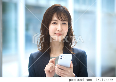 Business woman operating a smartphone Business woman operating a smartphone 132178276