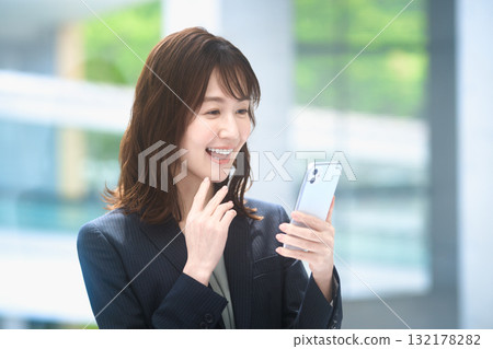 Business woman operating a smartphone Business woman operating a smartphone 132178282