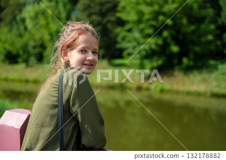 Beautiful teen girl in summer park. Portrait of happy girl smiling in a city park. Beautiful teen girl in summer park. Portrait of happy girl smiling in a city park. 132178882