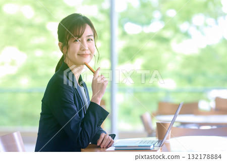使用便攜式計算機的婦女在咖啡館 使用便攜式計算機的婦女在咖啡館 132178884