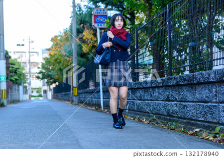 High school girls walking to and from school on a dark road on a cold day. High school girls' skirts, club activities, supplementary classes, going to and from school. 132178940