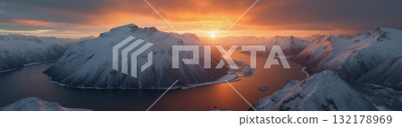 A beautiful northern landscape at sunset, with snow-covered mountains and a lake. 132178969