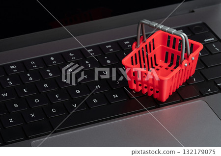 Red shopping basket sits on laptop keyboard Red shopping basket sits on laptop keyboard 132179075