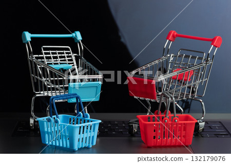 Colorful shopping carts on laptop keyboard symbolize shopping Colorful shopping carts on laptop keyboard symbolize shopping 132179076