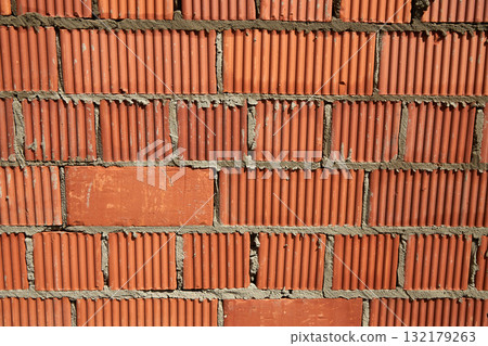 Brick wall construction with red clay bricks during daylight at a construction site Brick wall construction with red clay bricks during daylight at a construction site 132179263