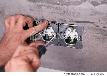 Home electrical repair in progress with tools and wiring on the wall 132179307