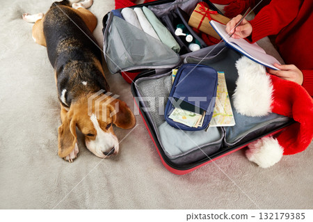 The girl is packing a suitcase for a trip to the Christmas holiday The girl is packing a suitcase for a trip to the Christmas holiday 132179385