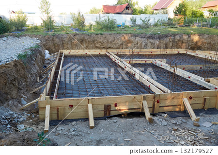 Construction site with wooden formwork and metal rebar. Building a house Construction site with wooden formwork and metal rebar. Building a house 132179527