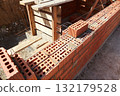 Brick wall construction in progress at a building site during daylight hours 132179528