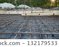 Steel reinforcement is laid in the form of a grid for the foundation of the building. 132179533