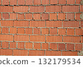 Brick wall construction with red clay bricks during daylight at a construction site 132179534