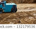 Blue roller compacts the ground on freshly dug soil at a construction site installed 132179536