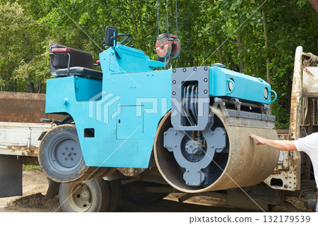 Mounting a compact roller on a truck for transportation to a construction site Mounting a compact roller on a truck for transportation to a construction site 132179539