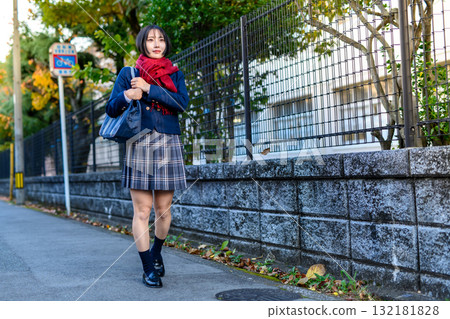 High school girls walking to and from school on a dark road on a cold day. High school student skirts, club activities, supplementary classes, going to and from school, warm and bright colors. 132181828