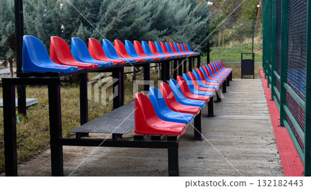 Red and blue seats await spectators at a Stadium Red and blue seats await spectators at a Stadium 132182443