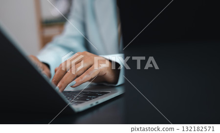 Business Professional Typing on Laptop Computer in Modern Office 132182571