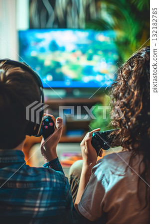 happy couple playing video game with controller on play station at home, friends play computer games on console and have fun 132182785