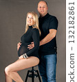 Pregnant woman and her husband posing in studio elegant maternity photo with loving couple awaiting baby 132182861