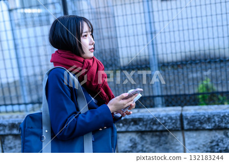 High school girls going to and from school on cold days using smartphones High school students going to school in winter clothes Blazers 132183244