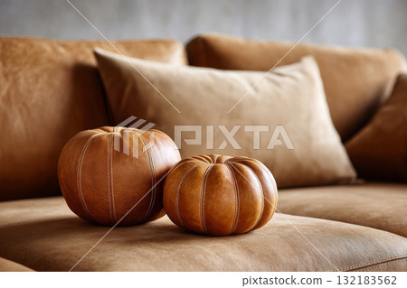 Decorative leather pumpkins on a cozy sofa, creating a warm autumn atmosphere for Halloween 132183562