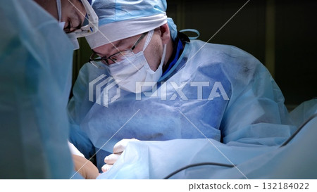 Surgical team performing precise medical procedure, wearing protective gear and concentrating during critical operation in sterile hospital environment Surgical team performing precise medical procedure, wearing protective gear and concentrating during critical operation in sterile hospital environment 132184022