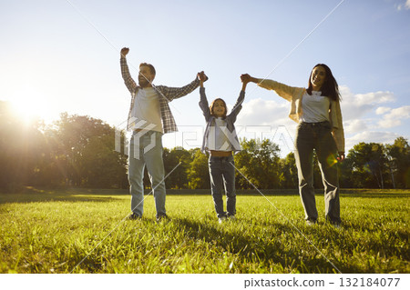 Summer walk in park of happy family, father, mother and kid standing with hands up, holding palms 132184077