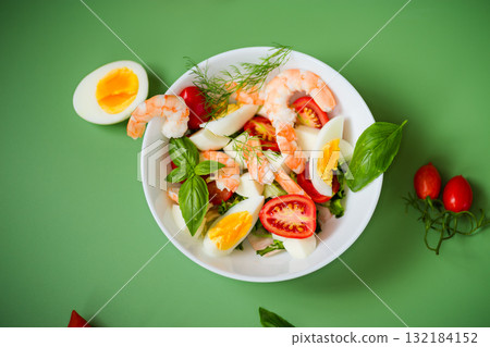 Bowl of fresh salad with seafood flavor and greens on a green background Bowl of fresh salad with seafood flavor and greens on a green background 132184152