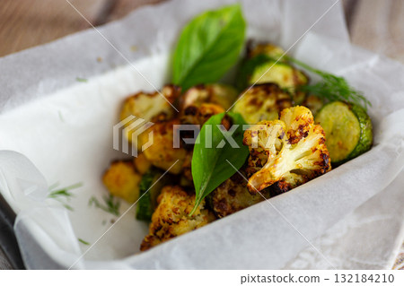 Healthy roasted zucchini and cauliflower with herbs and spices 132184210