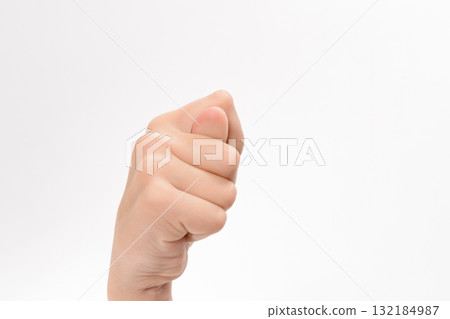 Close-up of a hand making a fist, thumb tucked inside. Isolated on a white background. 132184987