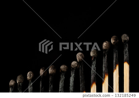 Rising line of burnt matches against black background. Concept of uprise movement, positive statistics, elevation Rising line of burnt matches against black background. Concept of uprise movement, positive statistics, elevation 132185249