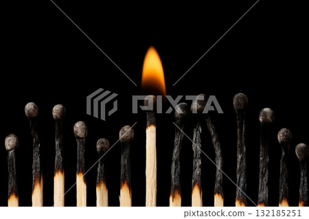 Group of burnt mathces with one still burning in the middle. Concept of firmness, power. 132185251