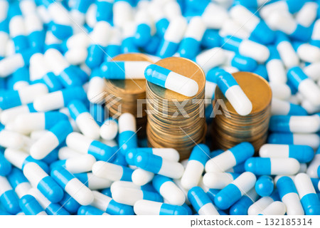 Stack of money coins between countless medical pills. Economy and medicine concept 132185314
