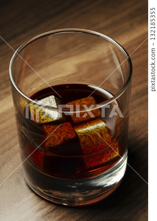 Whiskey glass with whiskey stones on wooden table 132185355