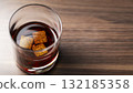 Glass of whiskey with chilling stones on wooden surface 132185358