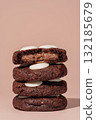 Stack of chocolate cookies with creamy filling and white chocolate topping on a soft background with copy space 132185679