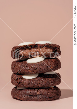 Stack of chocolate cookies with creamy filling and white chocolate topping on a soft background with copy space 132185679