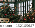 Festive Christmas trees adorned with ornaments and lights in a cozy holiday setting 132185687