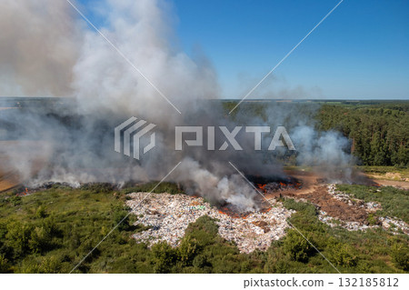 Burning garbage dump at summer. Polluting air with toxic gases 132185812