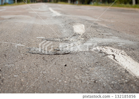 Overloaded truck ruined asphalt road and made its rusfase uneven with bumps Overloaded truck ruined asphalt road and made its rusfase uneven with bumps 132185856