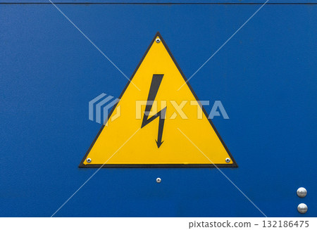 A bright yellow triangular warning sign with a black lightning bolt A bright yellow triangular warning sign with a black lightning bolt 132186475