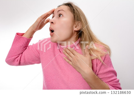 Surprised woman with hand on forehead and chest, looking up. Surprised woman with hand on forehead and chest, looking up. 132186630