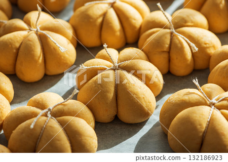 Pumpkin-Shaped Dough Pieces Tied with String on Baking Sheet Pumpkin-Shaped Dough Pieces Tied with String on Baking Sheet 132186923