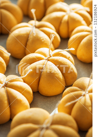 Pumpkin-Shaped Dough Pieces Tied with String on Baking Sheet Pumpkin-Shaped Dough Pieces Tied with String on Baking Sheet 132186924