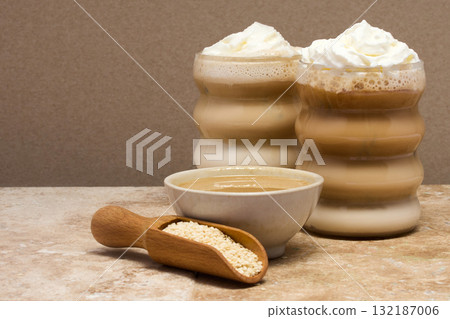 Creamy Tahini Latte Coffee and with tahini cream bowl and sesame seeds on a marble travertine 132187006