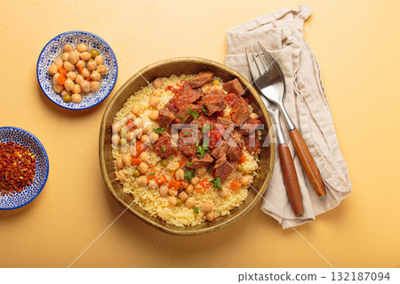 Moroccan couscous with tender meat and chickpea stew in rustic bow top view, Maghreb cuisine Moroccan couscous with tender meat and chickpea stew in rustic bow top view, Maghreb cuisine 132187094